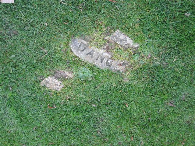 Danger sign half buried in grass